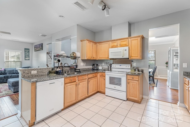 kitchen with visible vents, open floor plan, dark stone counters, light tile patterned floors, and white appliances