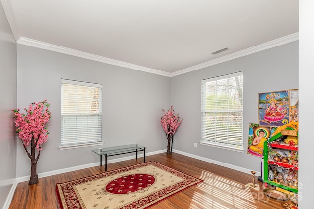 recreation room featuring visible vents, crown molding, baseboards, and wood finished floors