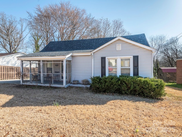 view of front of house featuring roof with shingles and fence