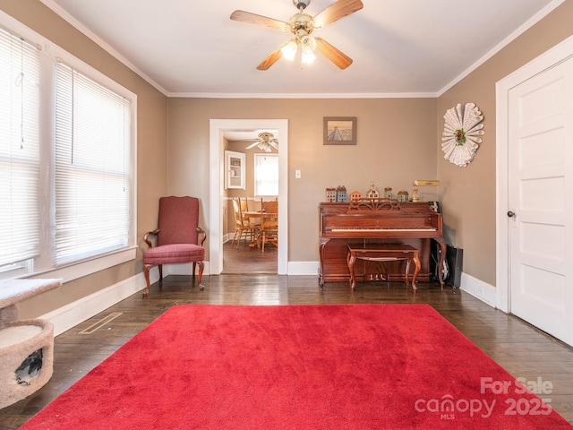 living area featuring ornamental molding, baseboards, and wood finished floors