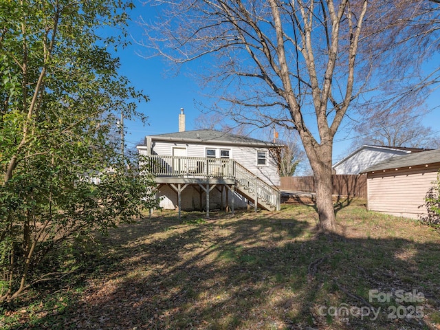 back of property with a lawn, a deck, stairs, fence, and a chimney