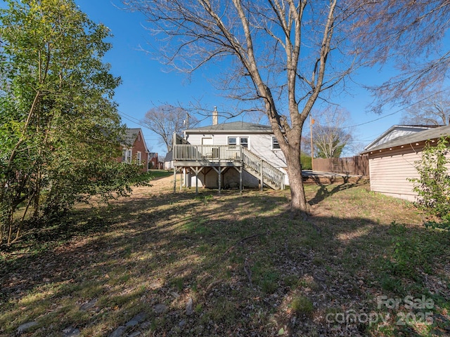 view of yard featuring a deck, stairs, and fence