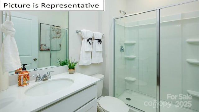 bathroom with vanity, toilet, and a stall shower