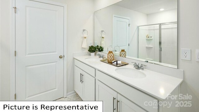 bathroom featuring a shower stall, double vanity, and a sink