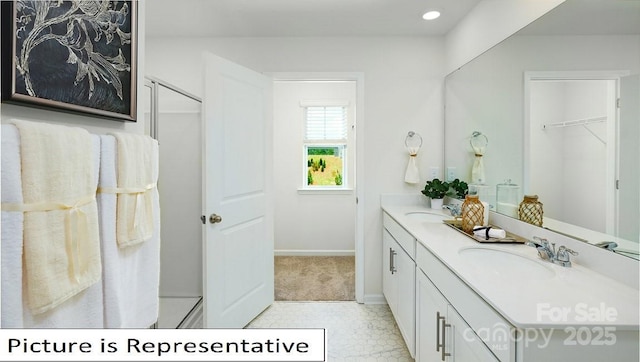 bathroom with double vanity, recessed lighting, baseboards, and a sink