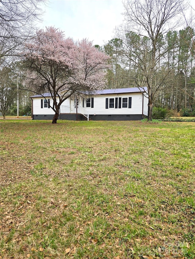 view of front of property with crawl space, metal roof, and a front yard