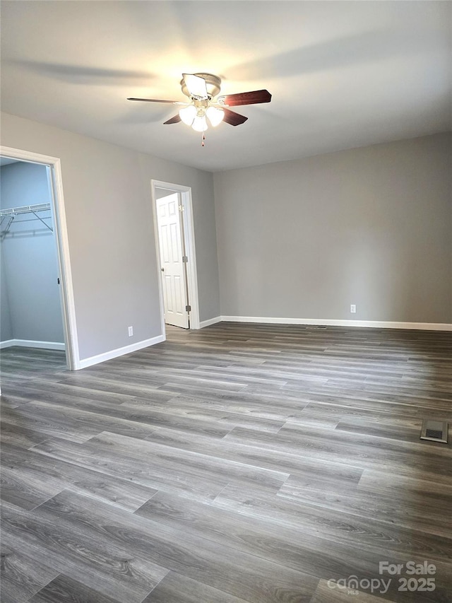 unfurnished room with ceiling fan, baseboards, and wood finished floors