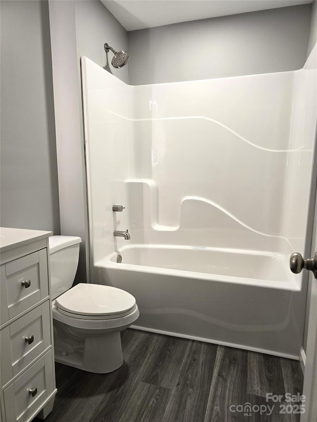 full bath featuring shower / washtub combination, toilet, vanity, and wood finished floors