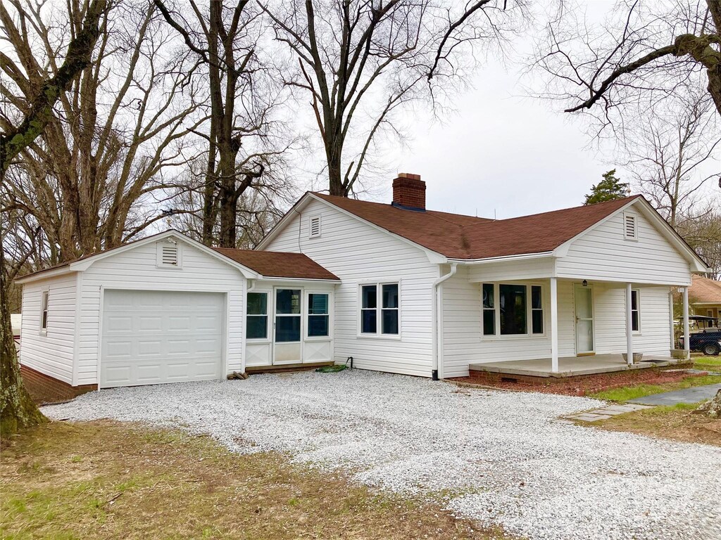 211 W 1st St, Landis, NC 28088 - view of front facade with an attached garage, a porch, roof with shingles, a chimney, and driveway