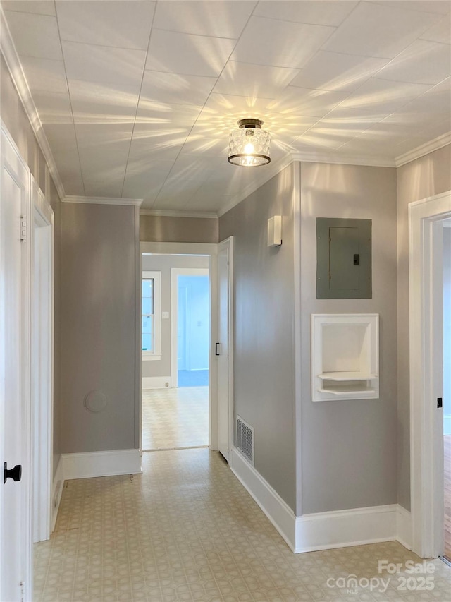 hallway featuring visible vents, baseboards, light floors, ornamental molding, and electric panel