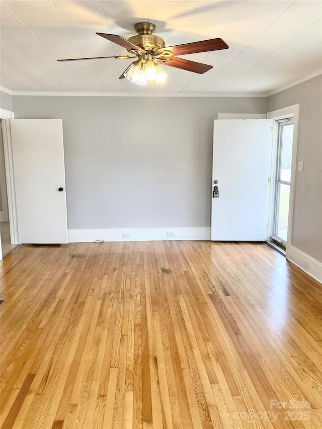 unfurnished room with light wood-type flooring, baseboards, a ceiling fan, and crown molding