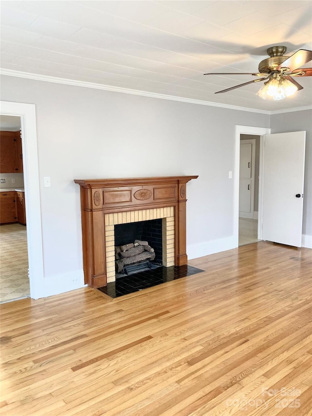 unfurnished living room with ornamental molding, a ceiling fan, light wood-style floors, a fireplace, and baseboards