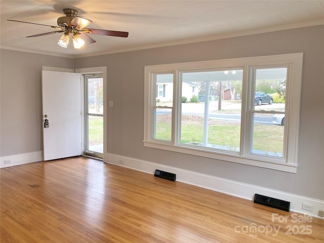 empty room with baseboards, light wood-style floors, visible vents, and ornamental molding