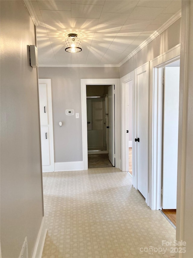 hallway with crown molding and baseboards