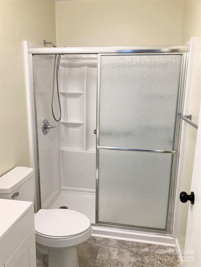 full bath with a stall shower, toilet, and vanity