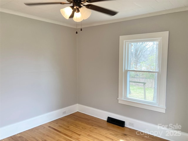 unfurnished room with visible vents, baseboards, ornamental molding, and light wood finished floors