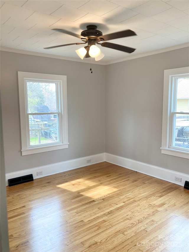 unfurnished room featuring ceiling fan, visible vents, wood finished floors, and crown molding