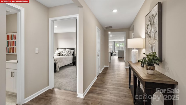 corridor featuring visible vents, recessed lighting, baseboards, and dark wood-style flooring