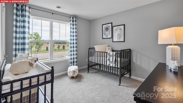 carpeted bedroom with visible vents, a nursery area, and baseboards