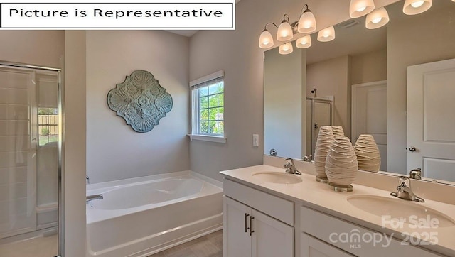 full bath featuring a sink, a garden tub, a stall shower, and double vanity