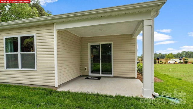 doorway to property with a patio area and a yard