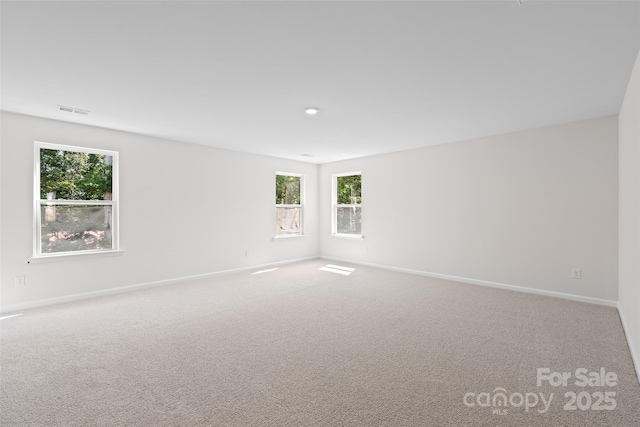 carpeted spare room with baseboards and visible vents