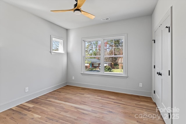 unfurnished bedroom featuring a ceiling fan, baseboards, visible vents, and light wood-type flooring