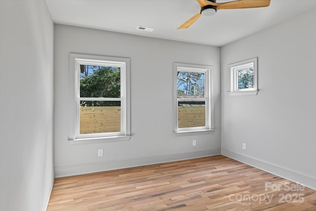 empty room with light wood-style flooring, baseboards, visible vents, and ceiling fan