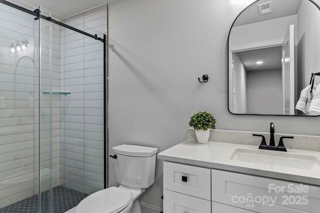 bathroom with vanity, toilet, visible vents, and a stall shower