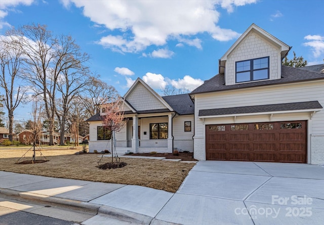 view of front of home with driveway, a shingled roof, a garage, and a porch