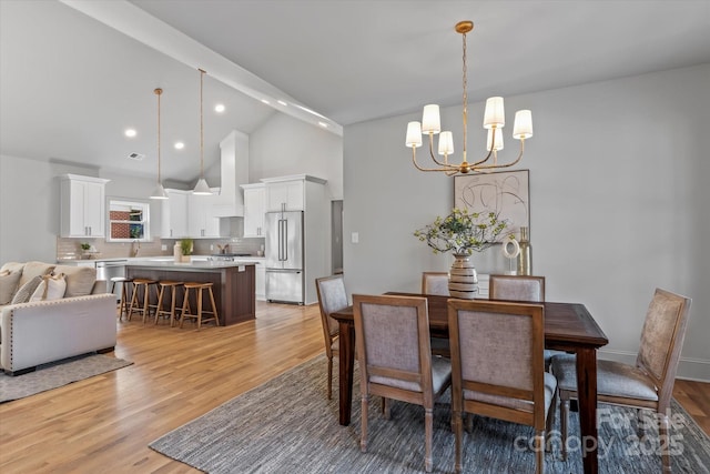 dining room featuring high vaulted ceiling, visible vents, recessed lighting, light wood-style floors, and a notable chandelier