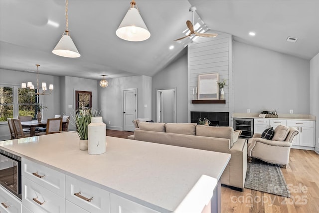 kitchen featuring stainless steel microwave, white cabinets, light countertops, and light wood-type flooring