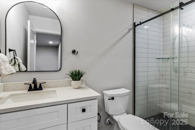 bathroom with toilet, vanity, and a stall shower