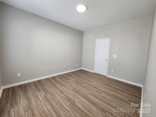 unfurnished room featuring baseboards and wood finished floors