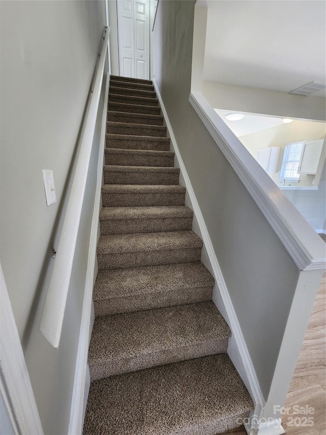 stairs with visible vents and baseboards