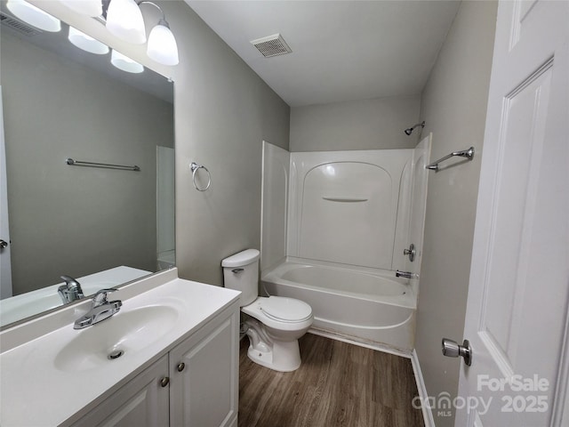 full bath featuring vanity, wood finished floors, visible vents, shower / bath combination, and toilet