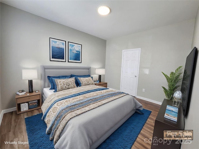 bedroom featuring baseboards and wood finished floors