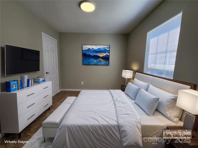 bedroom with baseboards and dark colored carpet