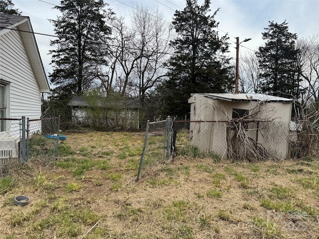 view of yard featuring an outbuilding, a gate, and fence