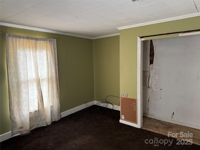 empty room featuring baseboards and ornamental molding