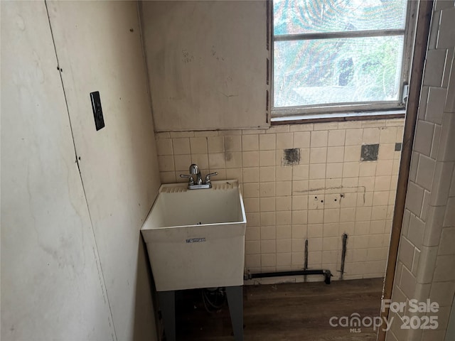 washroom featuring a sink, tile walls, and wood finished floors