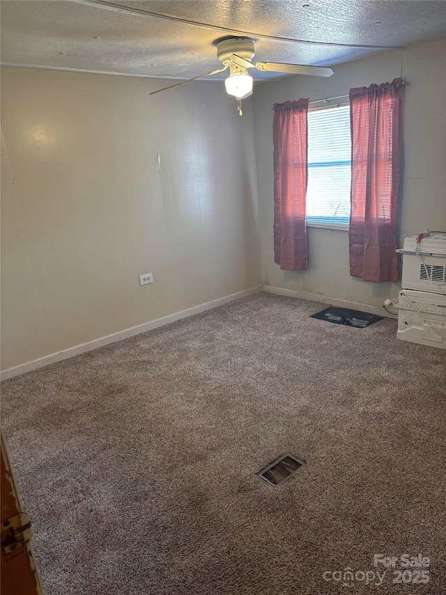 carpeted spare room with visible vents, baseboards, a textured ceiling, and ceiling fan