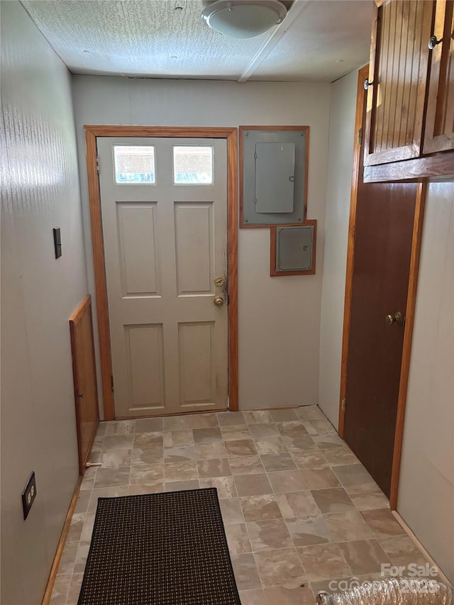 foyer with electric panel and a textured ceiling