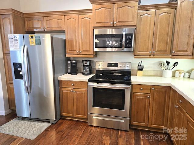 kitchen featuring dark wood-type flooring, light countertops, and stainless steel appliances