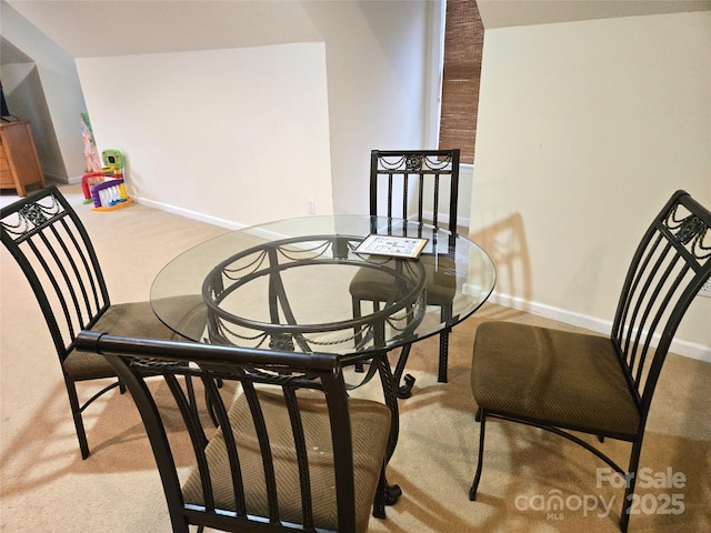 carpeted dining area featuring baseboards