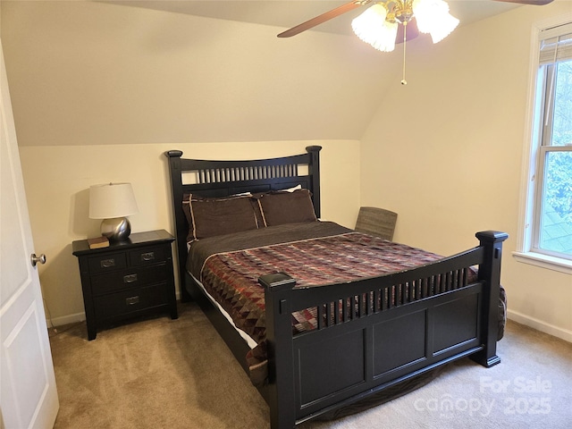 bedroom featuring a ceiling fan, vaulted ceiling, light colored carpet, and baseboards