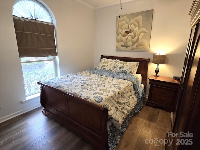 bedroom featuring dark wood-style floors, baseboards, and ornamental molding