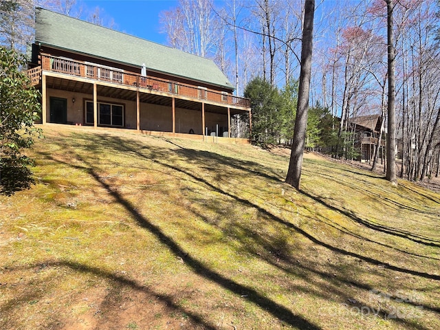 back of house featuring a lawn and a wooden deck