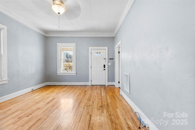 foyer with light wood-style flooring, baseboards, visible vents, and ornamental molding