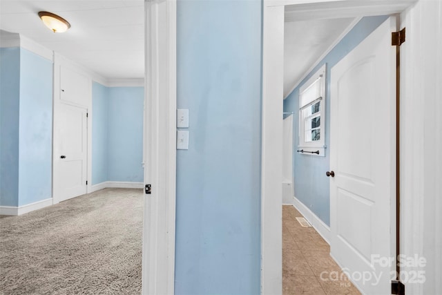 corridor featuring light carpet and baseboards